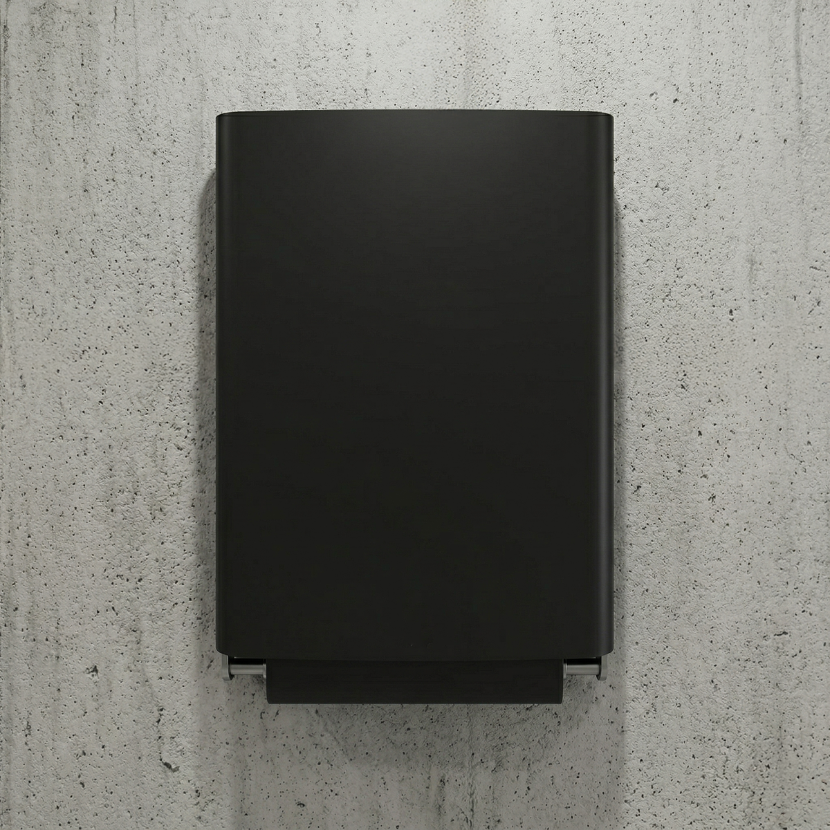 Black Dan Dryer Bjork baby changing station, folded closed on a concrete wall.