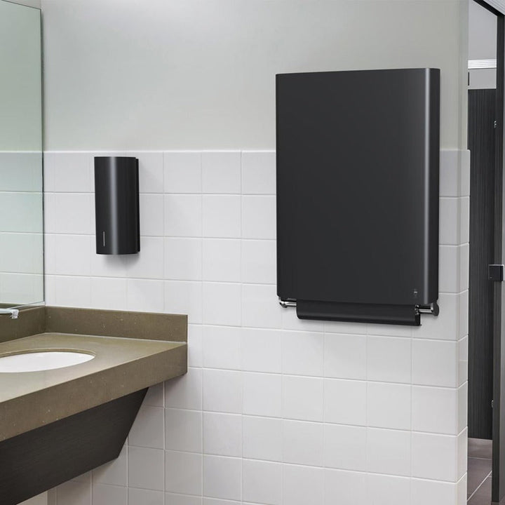 A bathroom with a sink, mirror, and Dan Dryer Bjork Baby Changing Station.