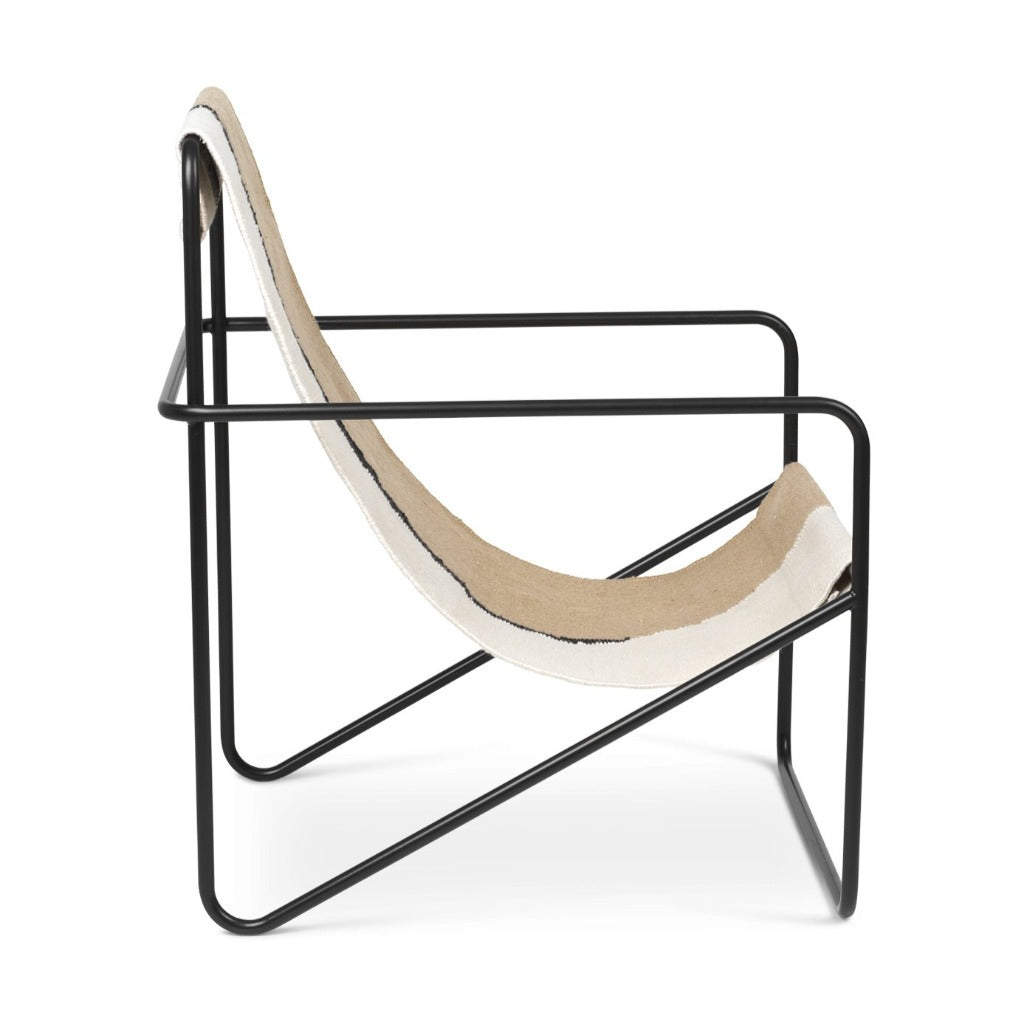 A Ferm Living Black Soil Desert Lounge Chair with white and black fabric on it.