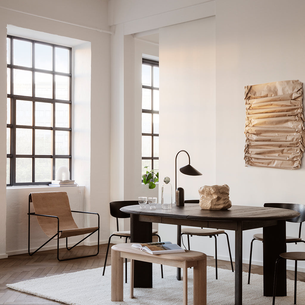 A living room with a Ferm Living Black Solid Desert Lounge Chair and table.