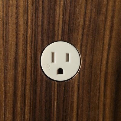 A close up of a wooden surface with a Bocci 22: Alternate Material Mounting light switch.