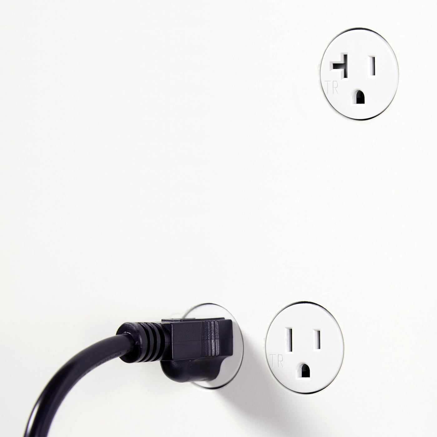 A black and white photo of two Bocci 22: Drywall Mud-In Mounting plugs on a white wall.