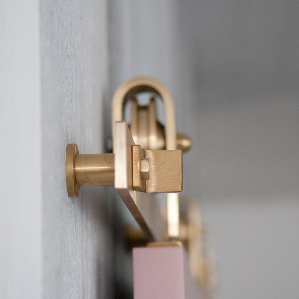 Pink Door with Brass barn door hardware detail 