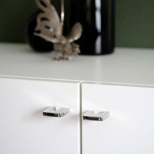 A close up of a drawer with a Baccman Berglund Bridge Knob in the background.