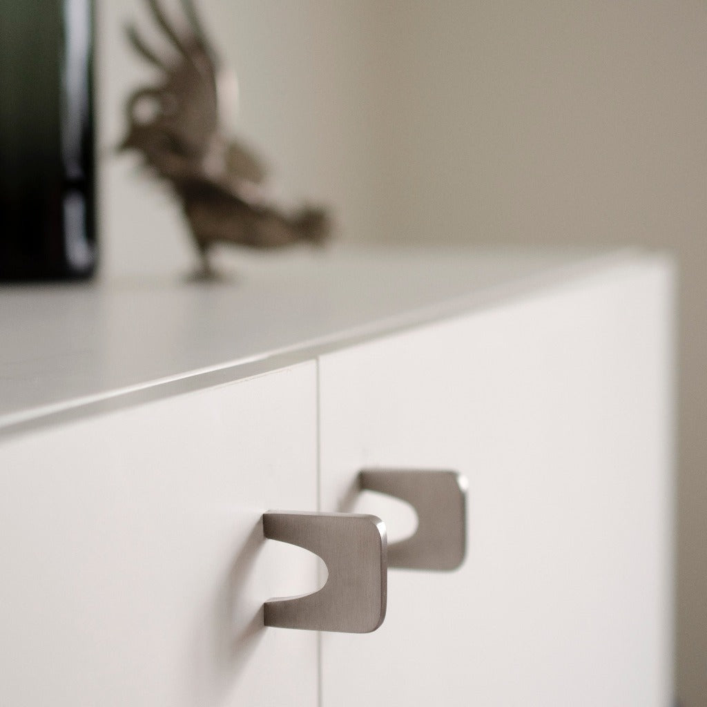 A close up of a drawer with a Baccman Berglund Bridge Knob on top of it.