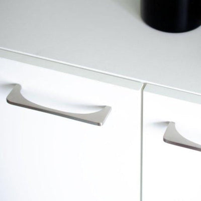 A close up of a drawer with a Baccman Berglund Bridge Pull on top of it.