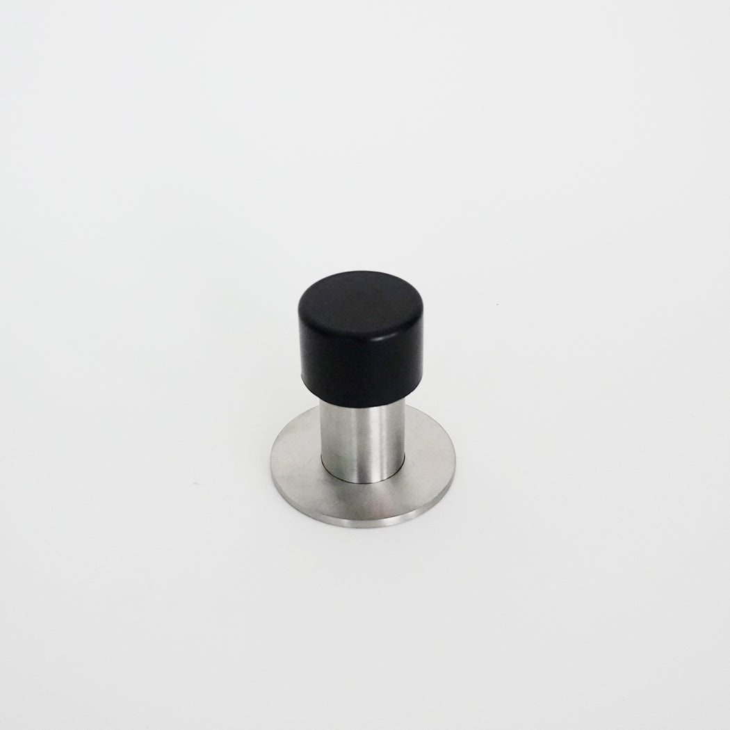 A black and silver AHI Capped Door Stop on a white surface.