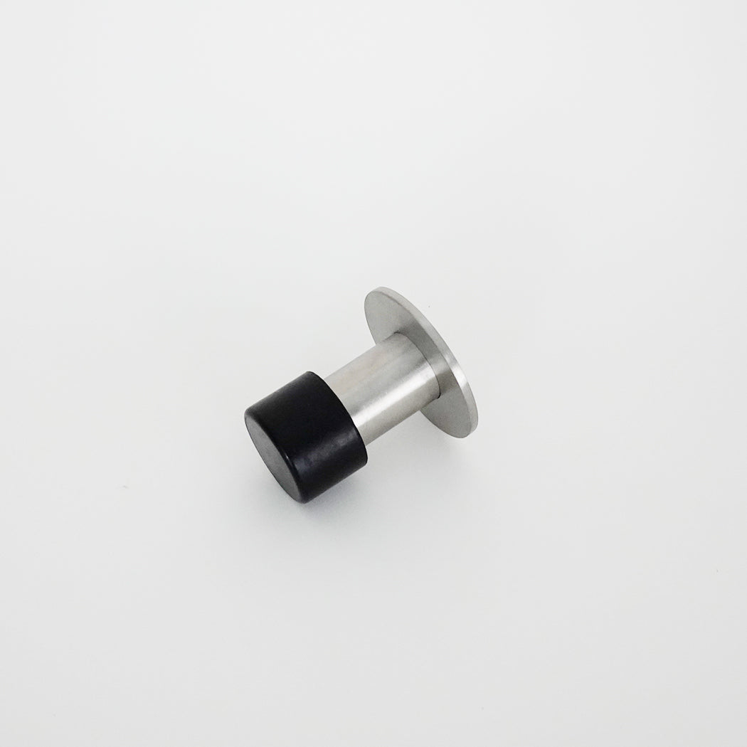 A close up of an AHI Capped Door Stop on a white surface.