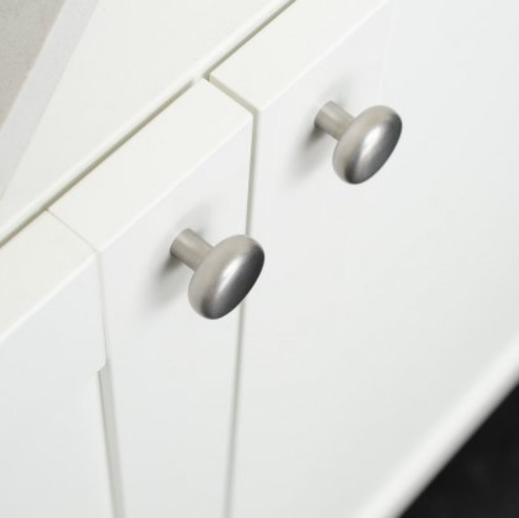 Close-up of white kitchen cabinets with silver knobs