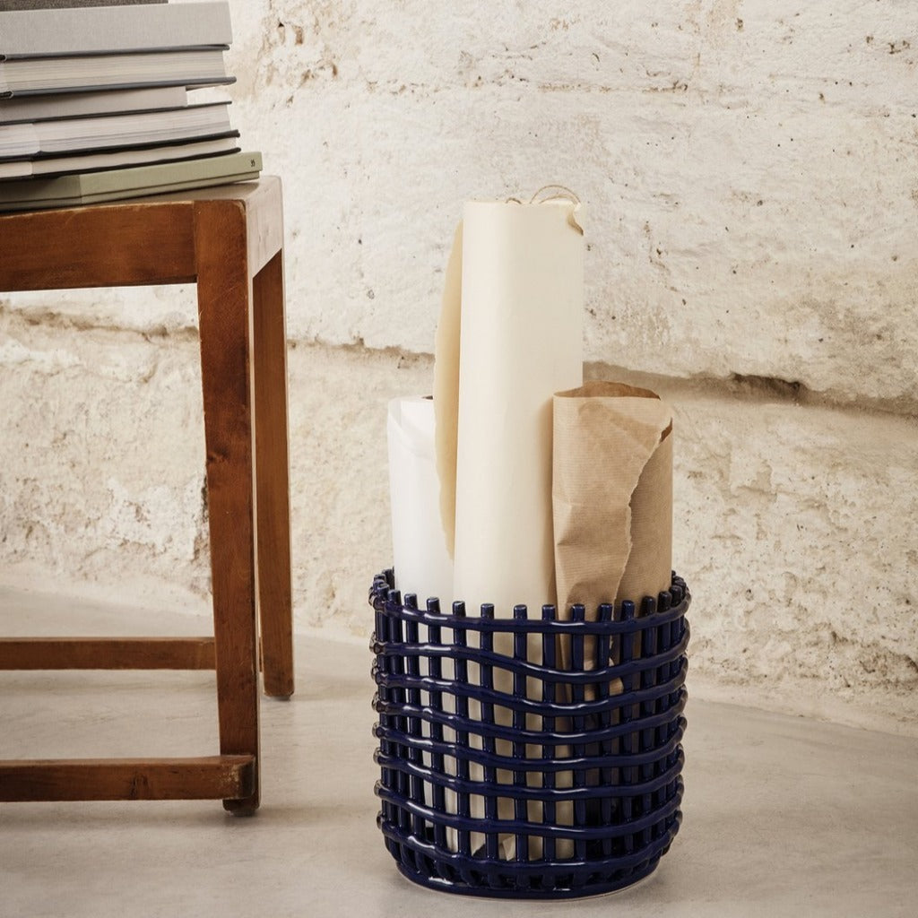 A Ferm Living Ceramic Woven Basket that has some paper in it.
