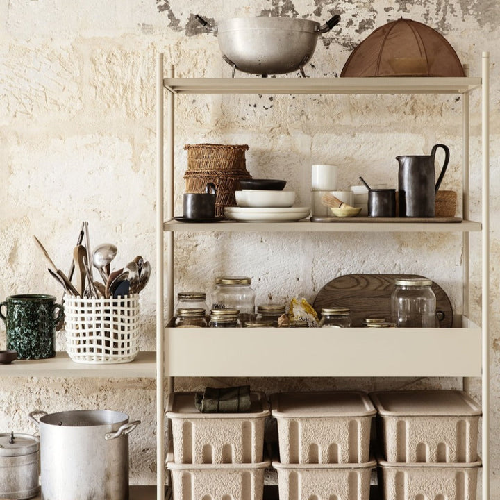 A Ferm Living Ceramic Woven Basket that has some containers on it.