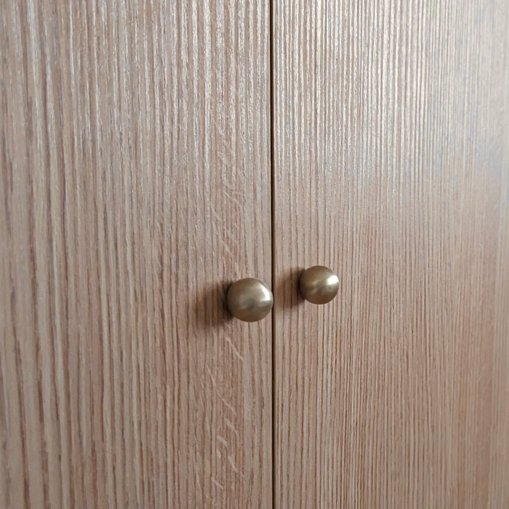 Satin brass Maha Alavi Cercle knobs or pulls on wood doors.