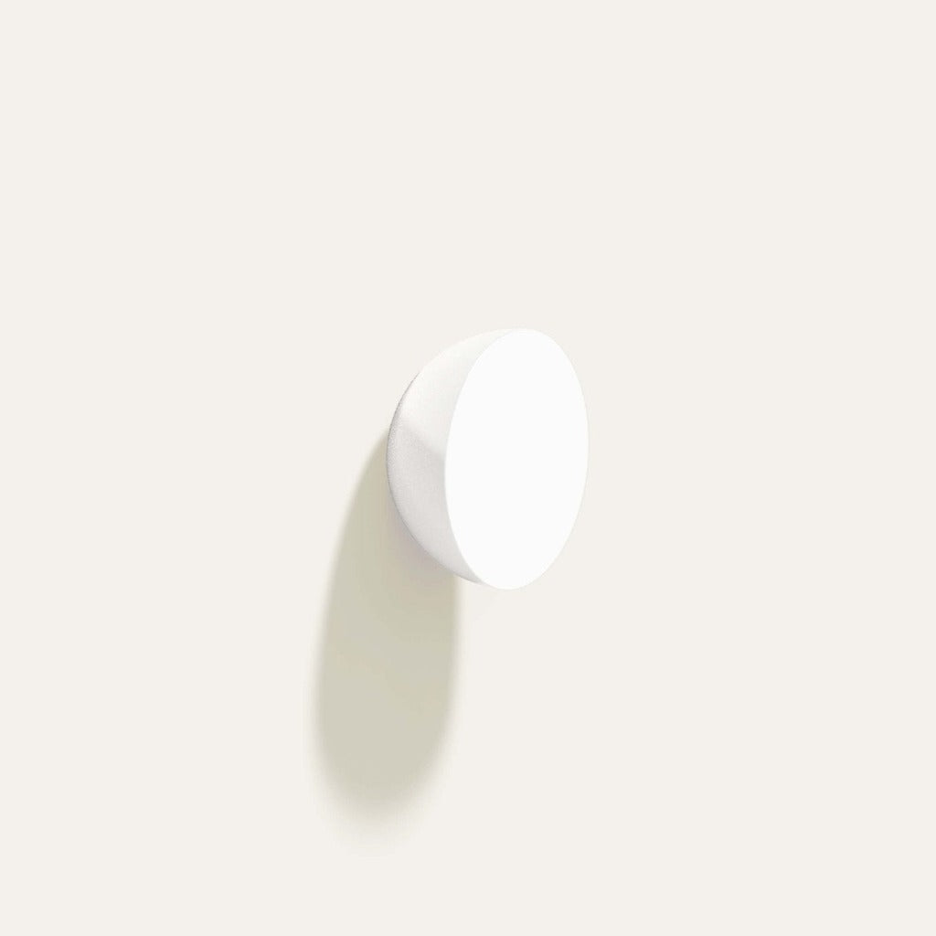 Cercle Knob in glossy white installed on a white wall.