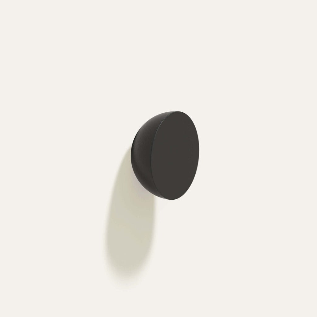 Cercle Knob in black installed on a white wall.