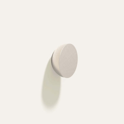 Cercle Knob in satin white bronze installed on a white wall.