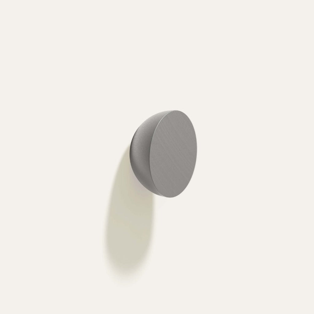 Cercle Knob in gunmetal installed on a white wall.