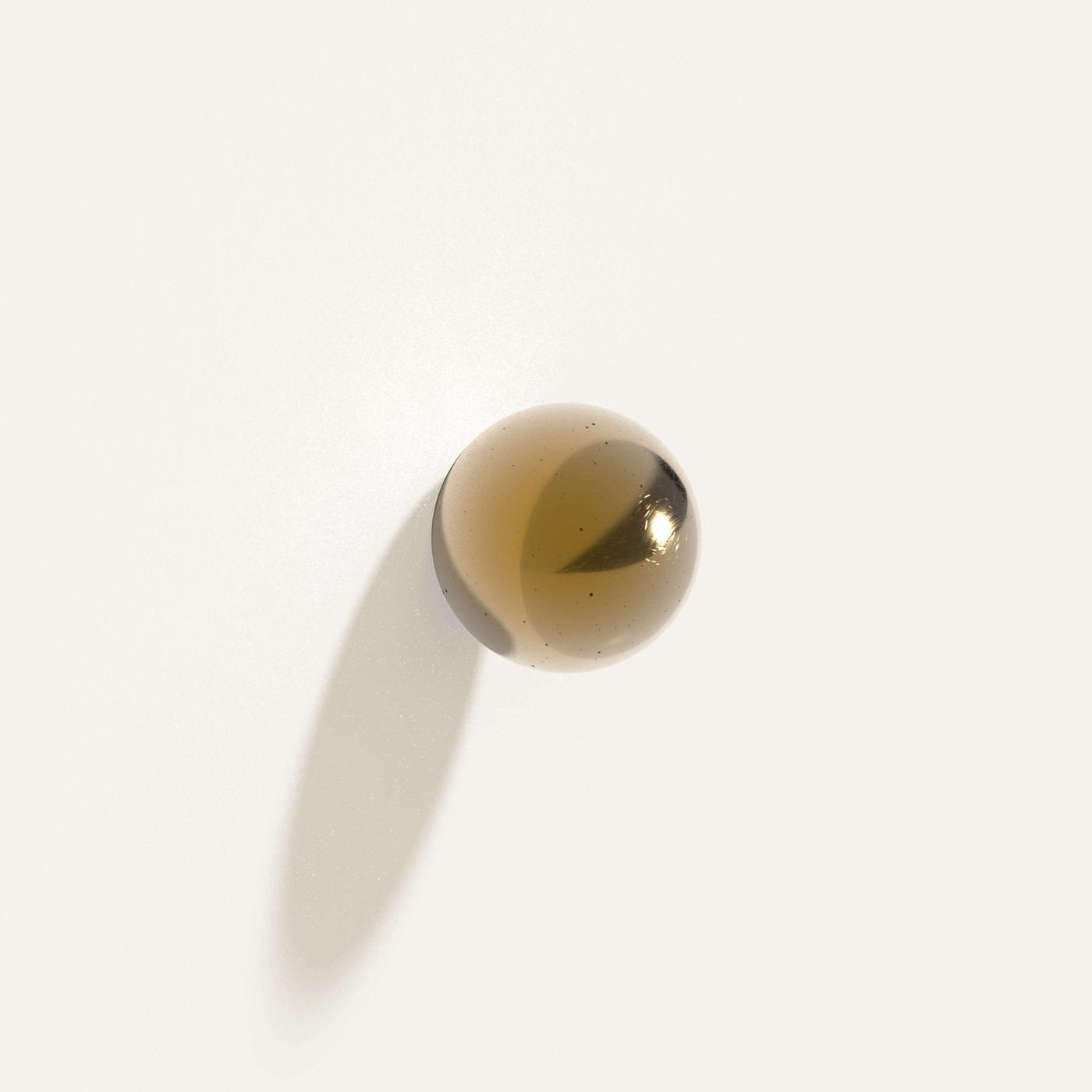 Cercle Knob Large in polished bronze installed on a white wall.