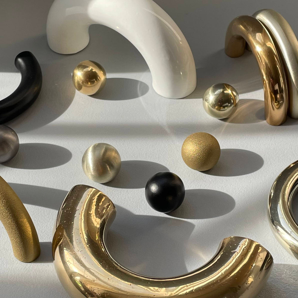 solid cast natural and white brass and bronze curved cabinet hardware handle by Maha Alavi