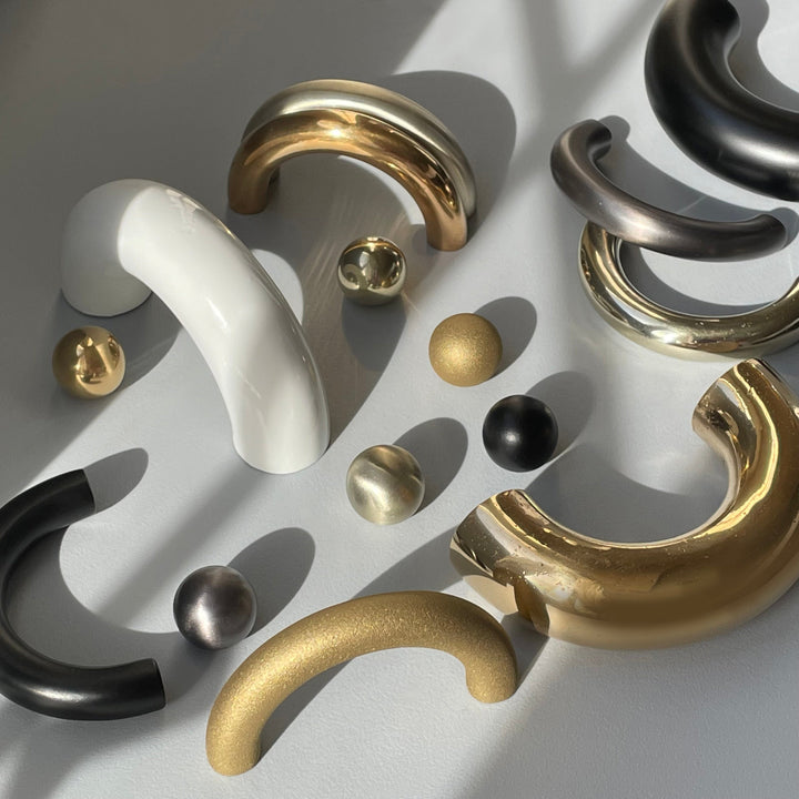solid cast natural and white brass and bronze curved cabinet hardware handle by Maha Alavi