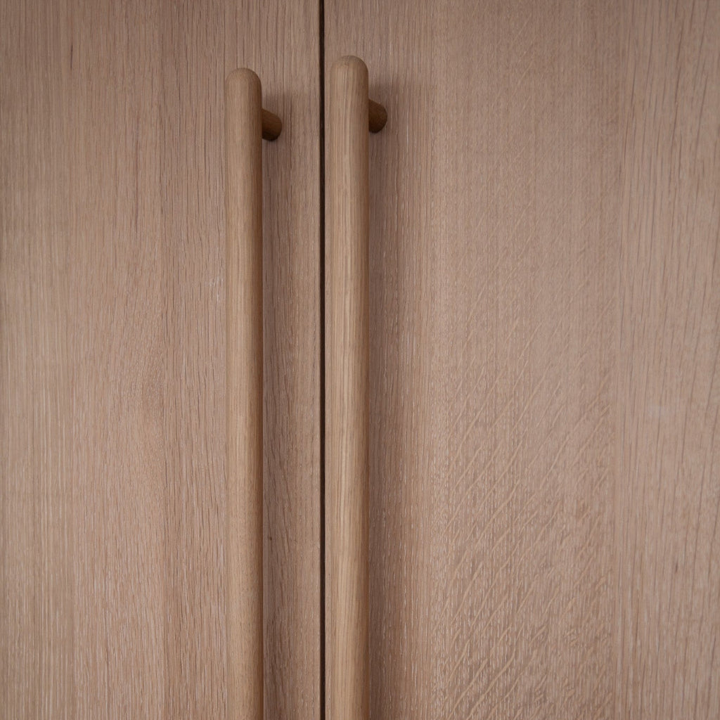 Oak Chapman & Bose wood bar pulls on cabinet doors.