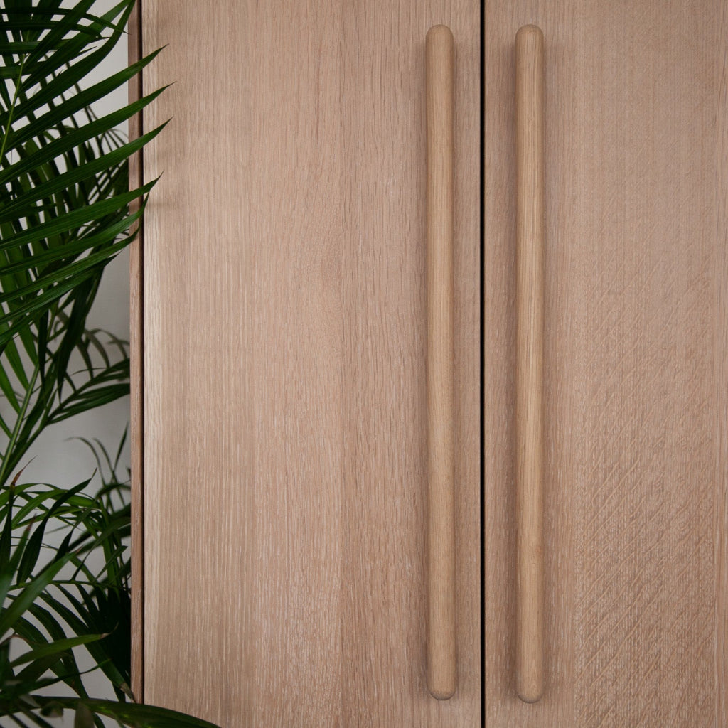 Oak Chapman & Bose wood bar pulls on a cabinet.