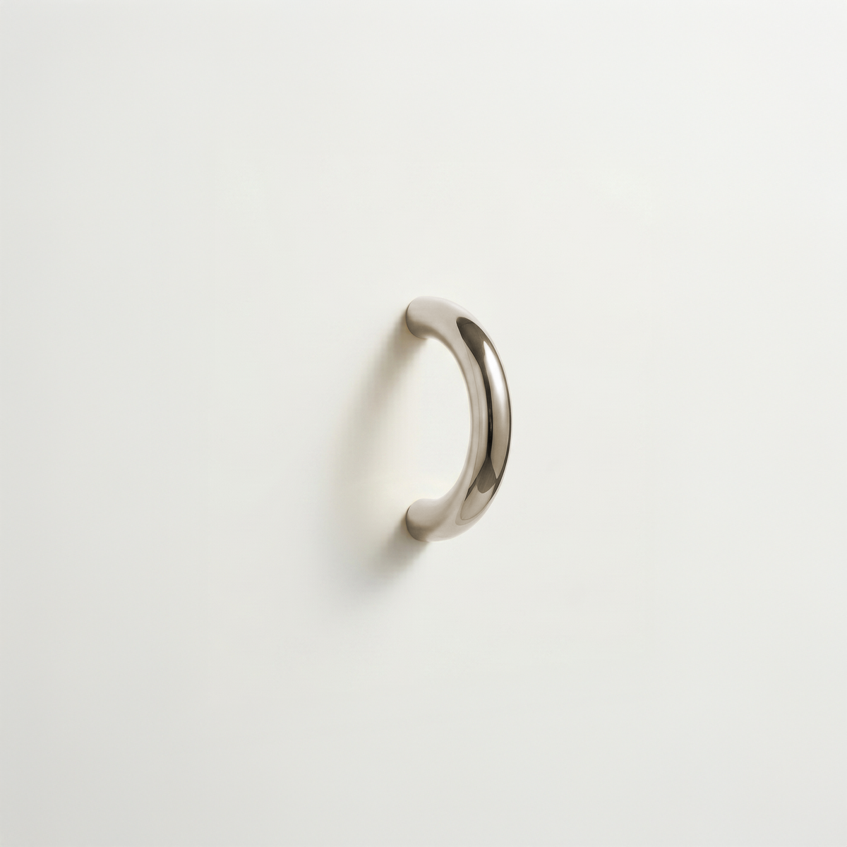 Satin nickel Charlie Arc pull, a small half-round arc handle, mounted on a white surface.
