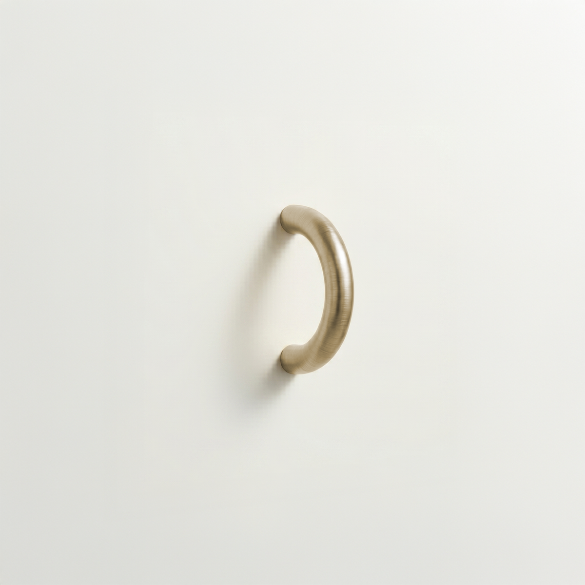 Satin brass Charlie Arc pull, a small half-round arc handle, mounted on a white surface.