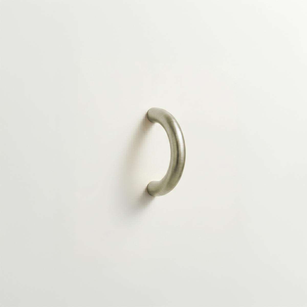 Satin nickel Charlie Arc pull, a small half-round arc handle, mounted on a white surface.
