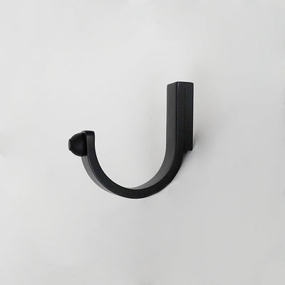 A close up of a CBH Charlie Bumper Hook on a white wall.
