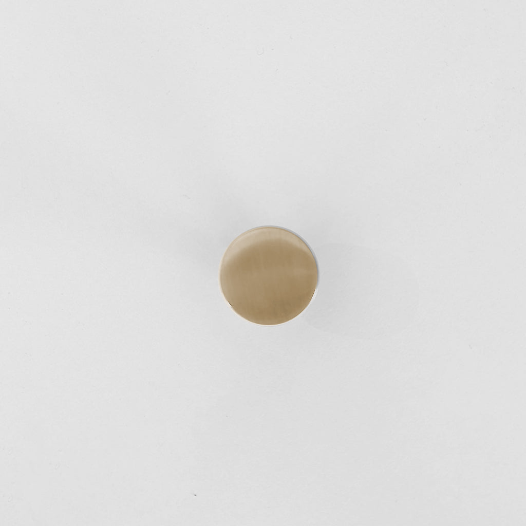 A white wall with a CBH Charlie Chunky Knob in gold on it.