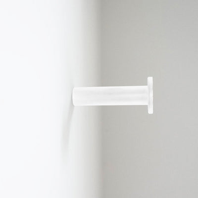 A white CBH Charlie Nail Hook mounted toilet paper dispenser.