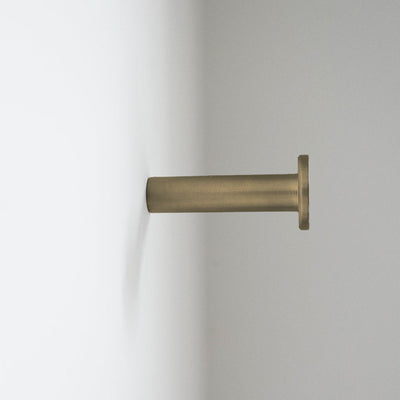 a close up of a CBH Charlie Nail Hook on a white wall.