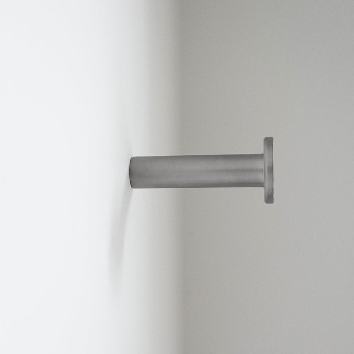 A close up of a CBH Charlie Nail Hook on a white wall.