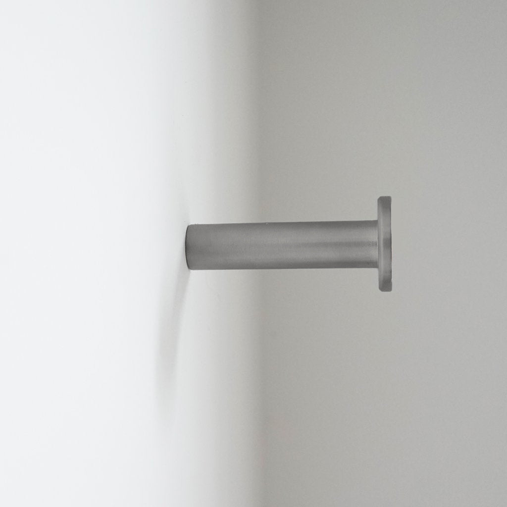 A close up of a CBH Charlie Nail Hook on a white wall.
