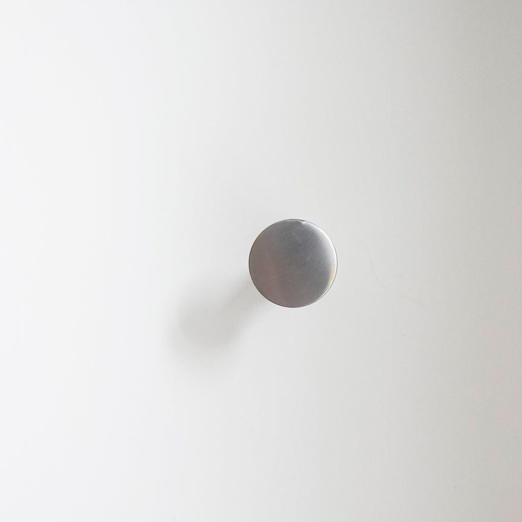 A white wall with a CBH Charlie Nail Hook on it.