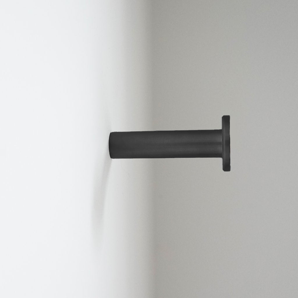 A CBH Charlie Nail Hook on a white wall.