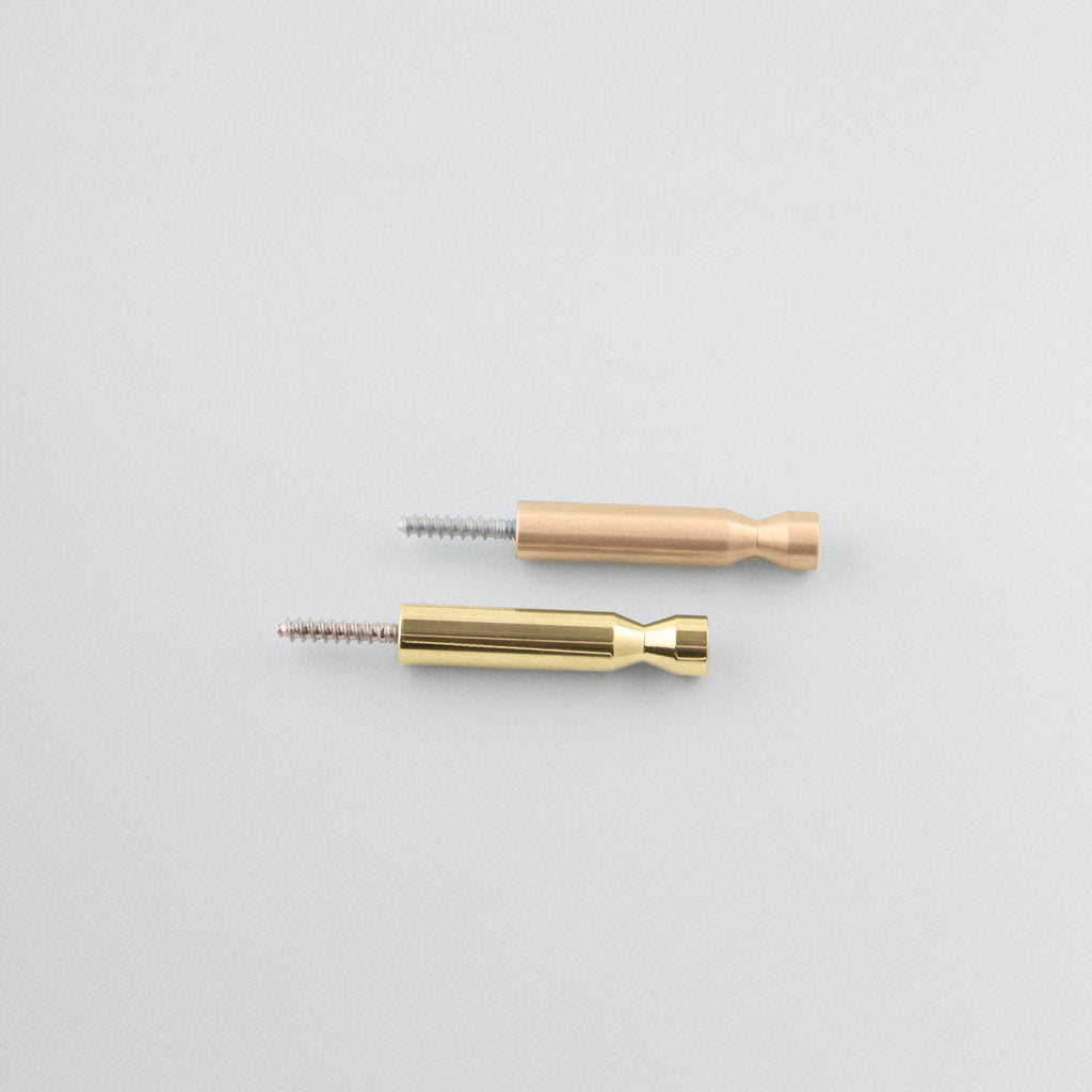 A pair of CBH Charlie Pencil Hooks sitting next to each other on a white surface.
