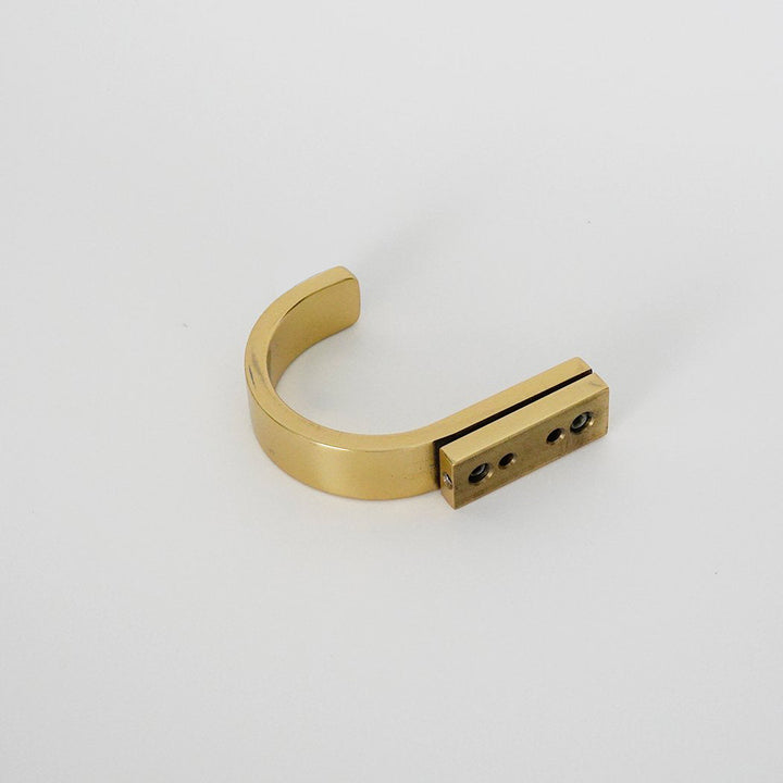 A CBH Charlie Round Hook in gold color on a white surface.