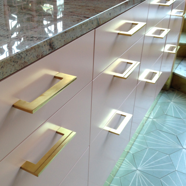Clean and modern brass handles on modern kitchen drawers.