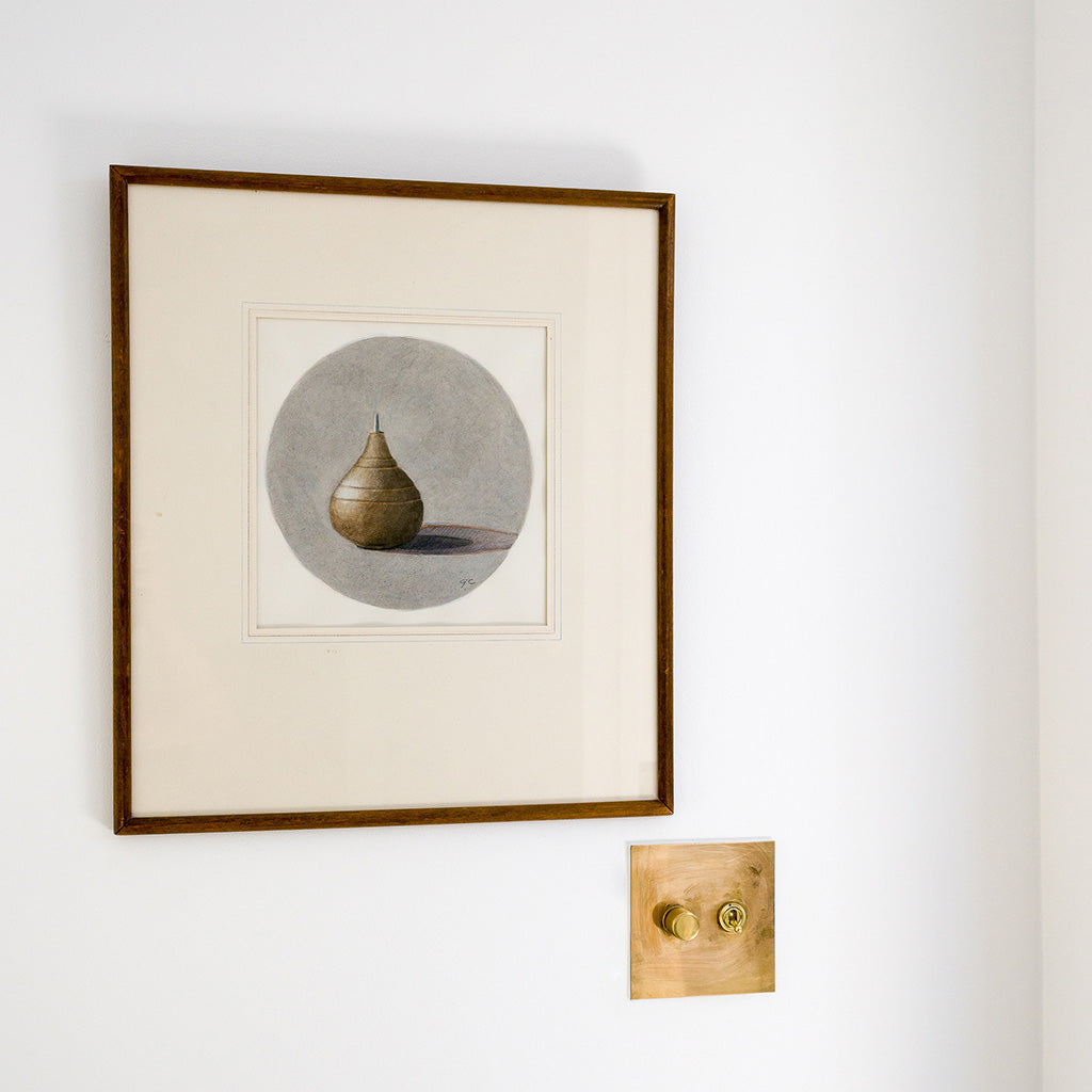 A brass Forbes & Lomax switch below framed art.