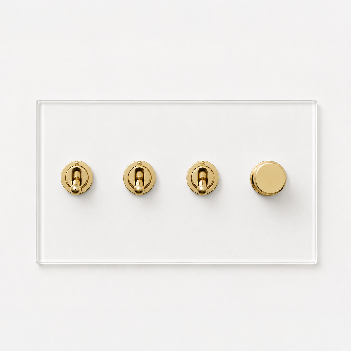 Forbes & Lomax transparent acrylic plate with three brass toggle switches and one rotary dimmer on a white background.