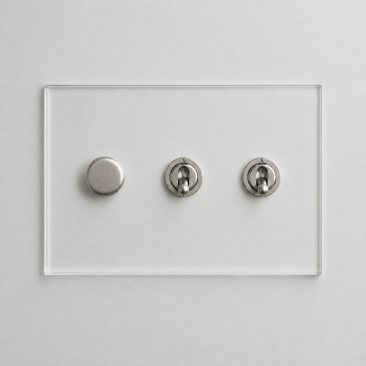 Forbes & Lomax invisible acrylic plate with one brushed nickel rotary dimmer and two matching toggle switches.