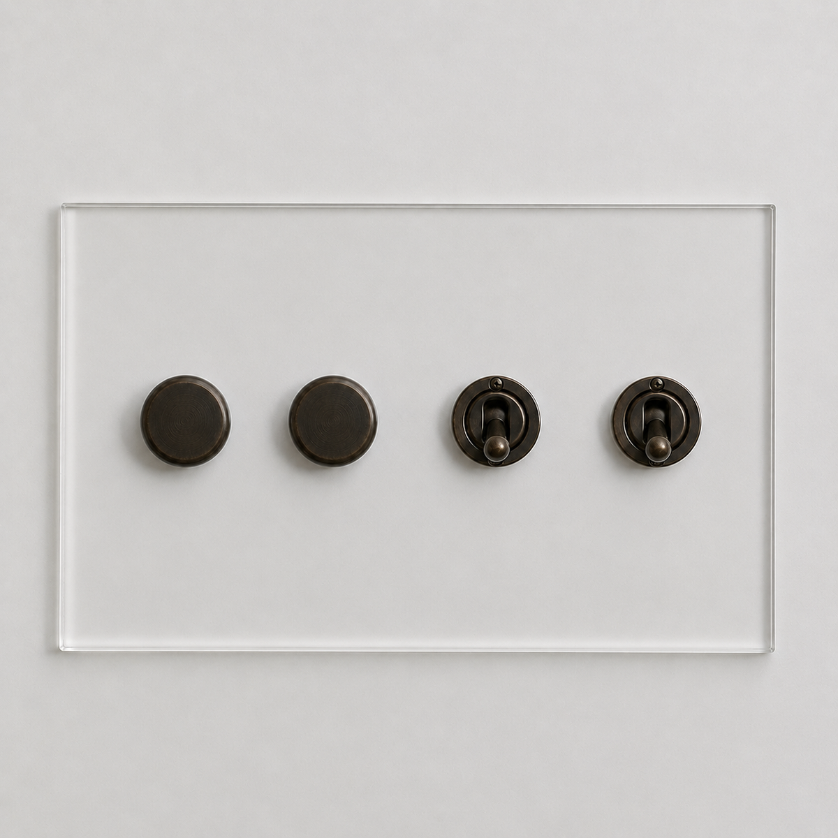 Forbes & Lomax Invisible clear acrylic plate with two bronze rotary dimmers and two bronze toggle switches.