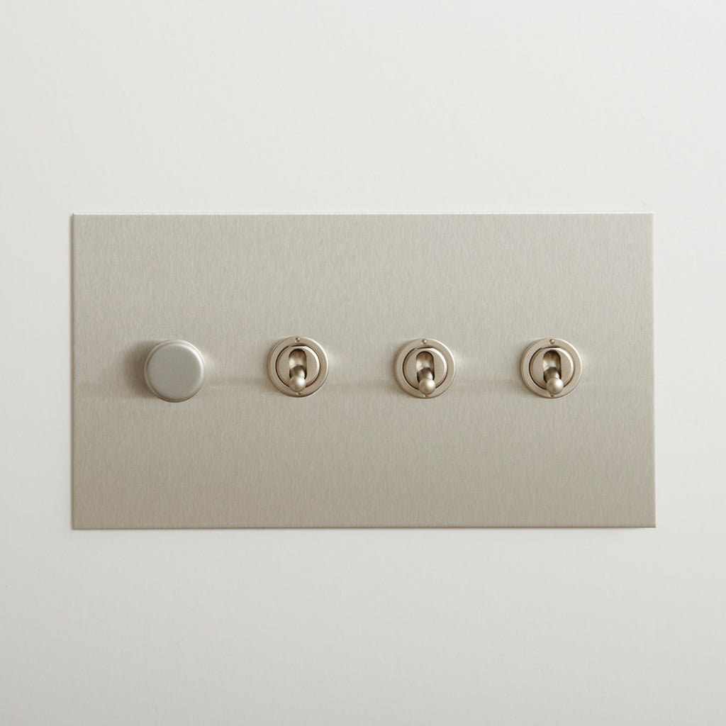 Nickel Forbes & Lomax switch plate with a dimmer and three toggles.