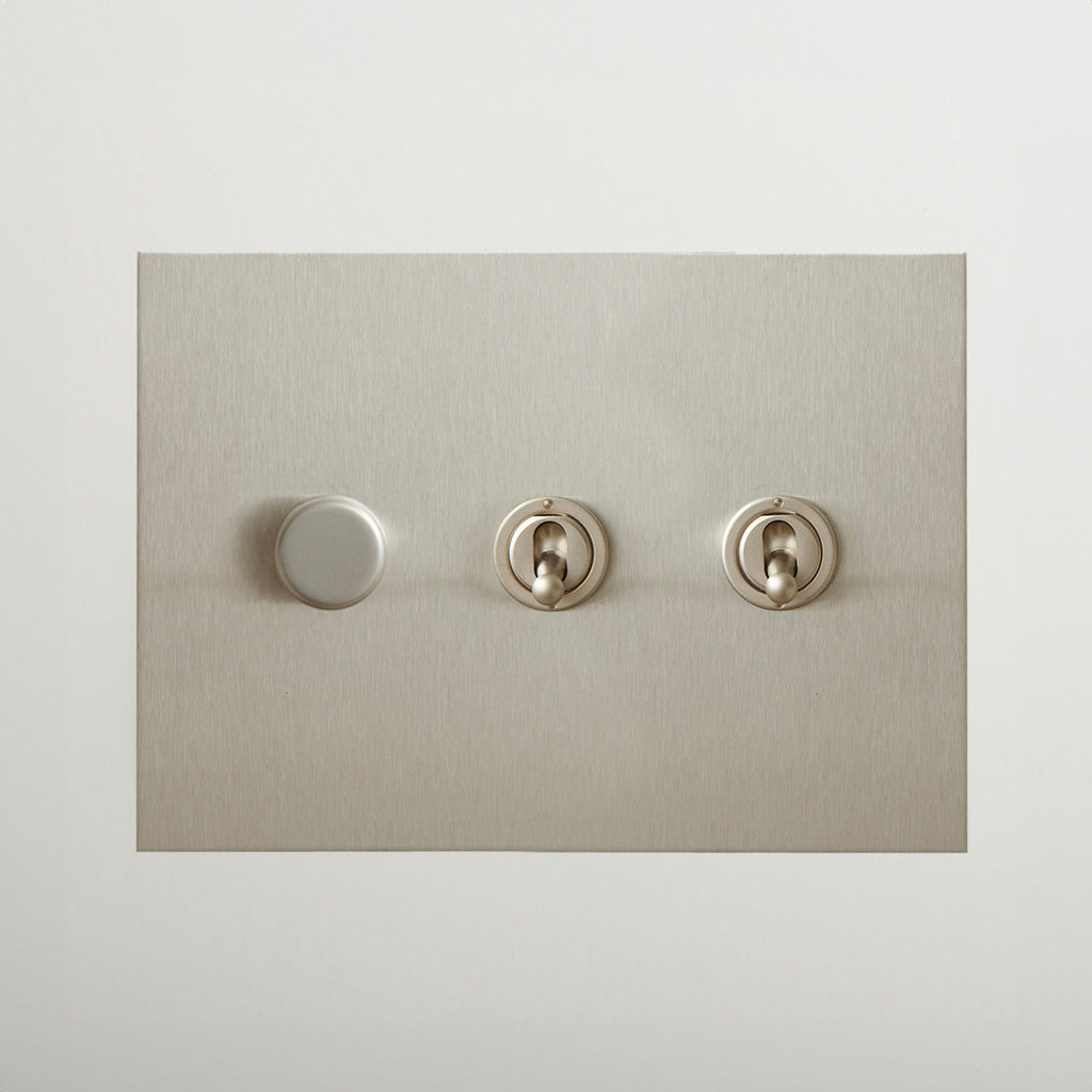 Nickel Forbes & Lomax switch plate with a dimmer and two toggles.