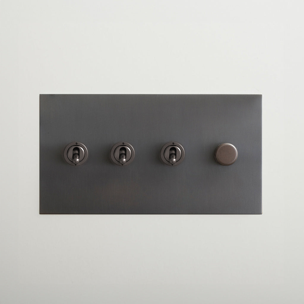 Antique bronze Forbes & Lomax switch plate with three toggles and a dimmer.