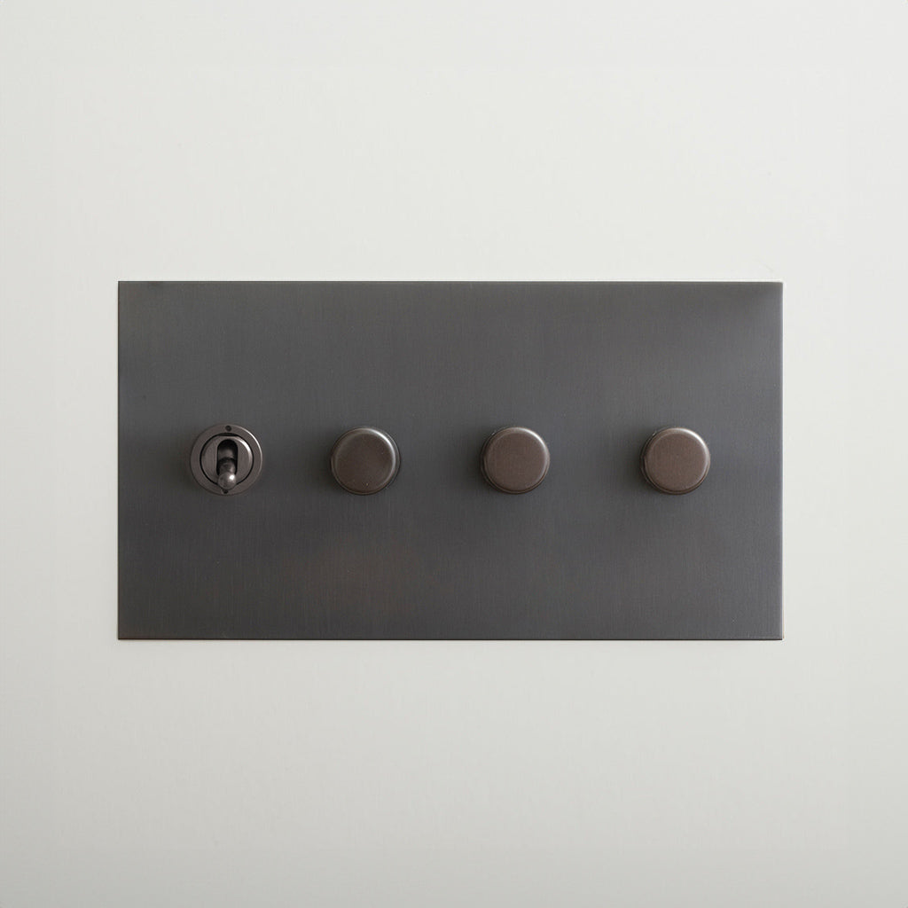 Antique bronze Forbes & Lomax switch plate with a toggle and three dimmers.
