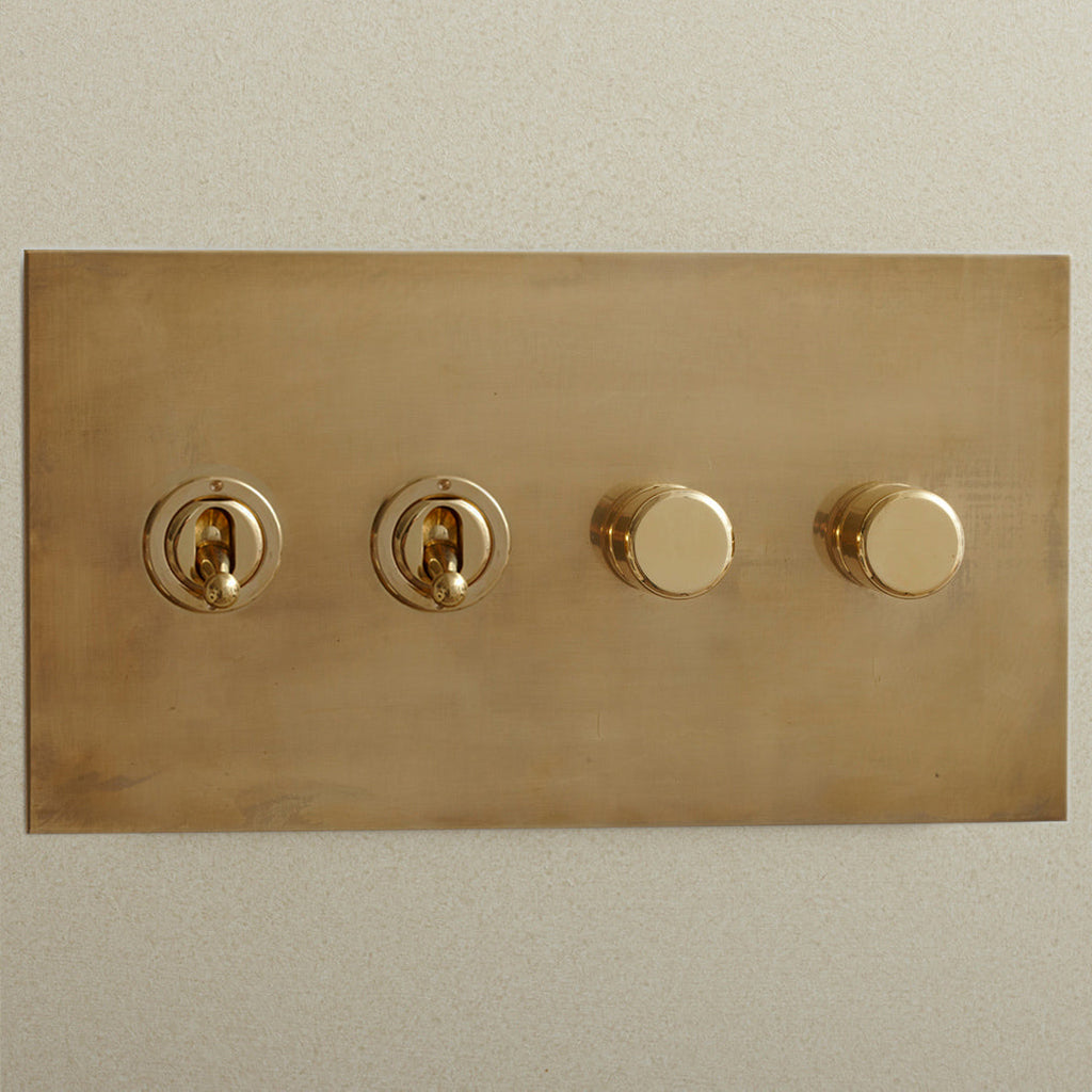Aged brass Forbes & Lomax switch plate with two toggles and two dimmers.