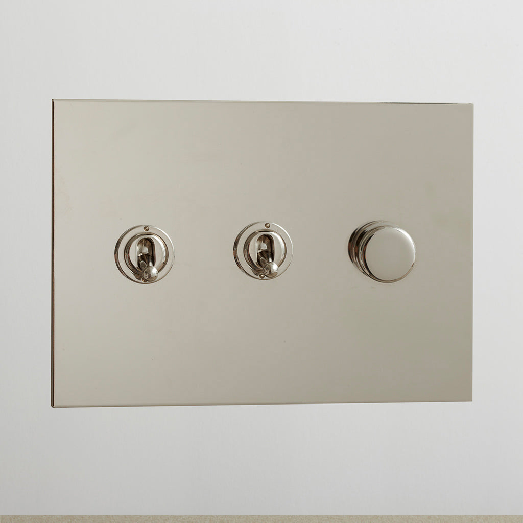 Nickel Forbes & Lomax switch plate with two toggles and a dimmer.