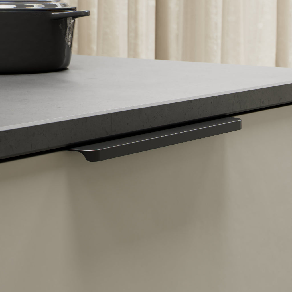 Matte black Furnipart Comet edge pull, 160 mm, on a light grey drawer under a dark countertop.